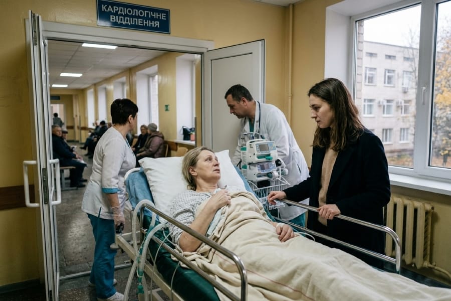 Жінка підтримує маму на лікарняній каталці в коридорі кардіологічного відділення, прийняття тіла після хвороби